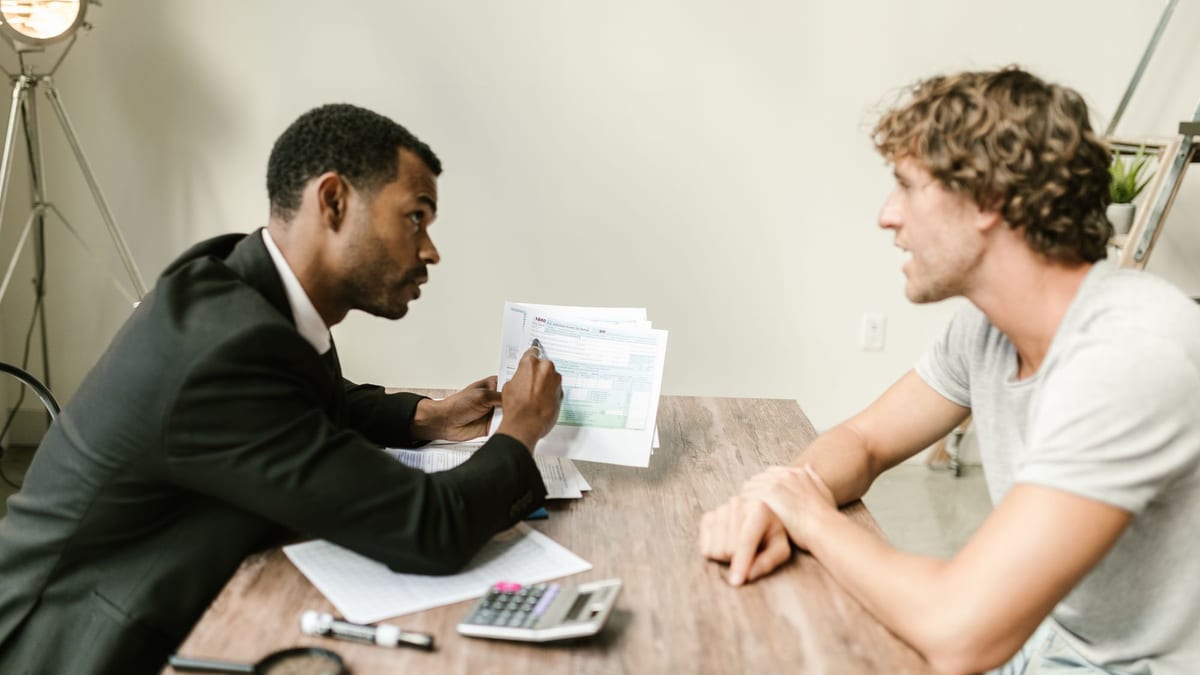An advisor and a client going through a financial document across a desk